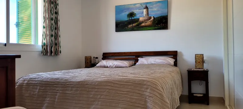 Schlafzimmer mit Doppelbett, Holzkopfteil und Nachttischlampen