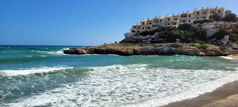 Sandstrand mit auflaufenden türkisen Wellen