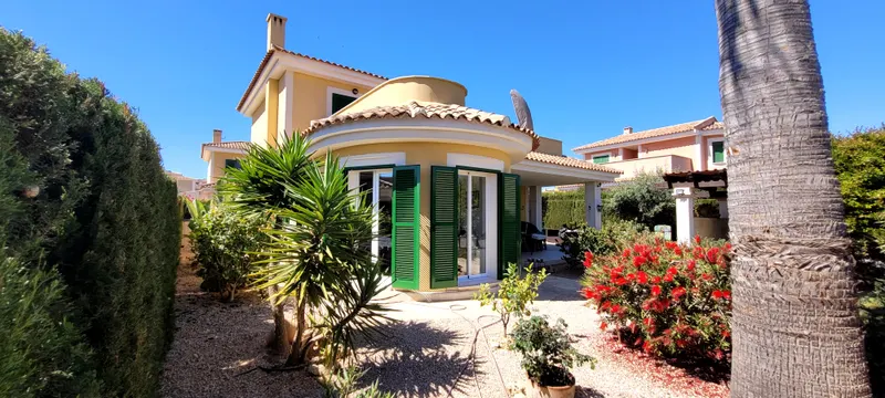Blick durch den Garten auf die Villa mit rundem Erker